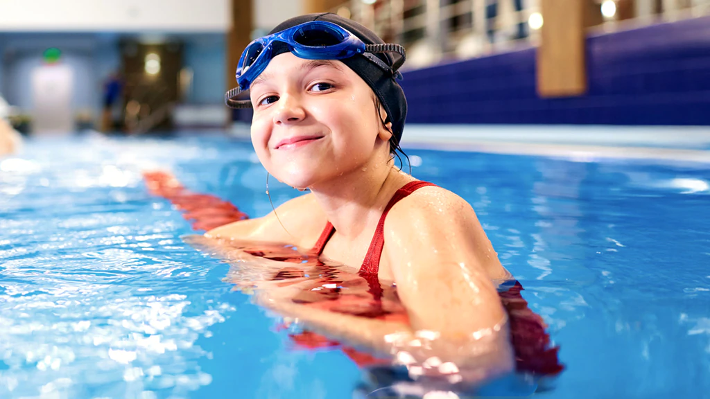 Nena nedant a una piscina interior